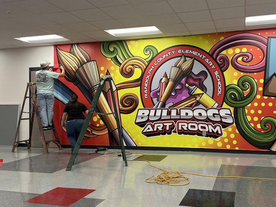 Installers hanging the Bulldogs Art Room mural at Randolph County Elementary